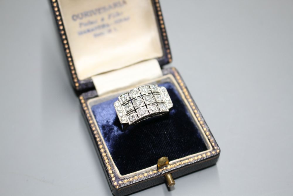 A white metal (stamped 750 and Pt 950) and pave diamond set cocktail ring, of curved design and set with twenty round cut stones.